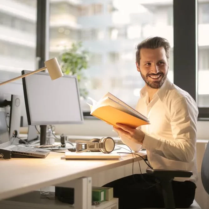 smiling man looking over his shoulder sitting at desk